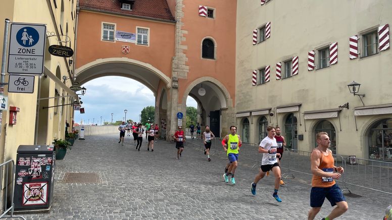 Die Läufer überqueren die Steinerne Brücke in Regensburg. | Bild:BR/Michael Buchner