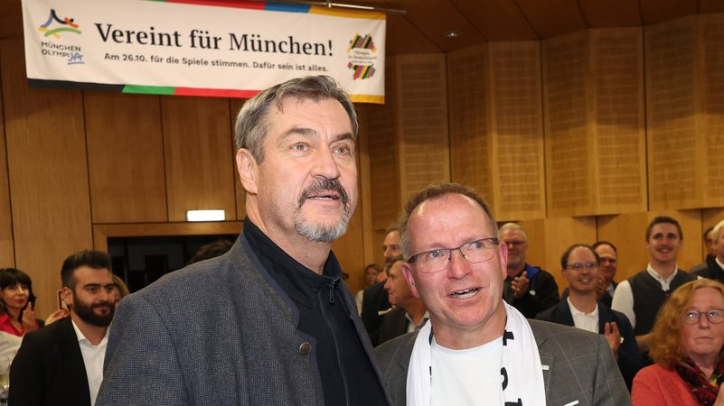 26.10.2025, Bayern, München: Markus Söder (CSU, l), Ministerpräsident von Bayern, und Jörg Ammon, Präsident des Bayerischen Landes-Sportverbands (BLSV), verfolgen die Bekanntgabe der ersten Hochrechnungen zum Ergebnis des Bürgerentscheids zur Olympia-Bewerbung auf einer Leinwand. Bei der Bürgerbefragung stimmten nach Angaben von Münchens Oberbürgermeister Reiter deutlich über 60 Prozent für eine Bewerbung der bayerischen Landeshauptstadt um Sommerspiele und Paralympische Spiele im Jahr 2036, 2040 oder 2044. | Bild: dpa-Bildfunk/Karl-Josef Hildenbrand 26.10.2025, Bayern, München: Markus Söder (CSU, l), Ministerpräsident von Bayern, und Jörg Ammon, Präsident des Bayerischen Landes-Sportverbands (BLSV), verfolgen die Bekanntgabe der ersten Hochrechnungen zum Ergebnis des Bürgerentscheids zur Olympia-Bewerbung auf einer Leinwand. Bei der Bürgerbefragung stimmten nach Angaben von Münchens Oberbürgermeister Reiter deutlich über 60 Prozent für eine Bewerbung der bayerischen Landeshauptstadt um Sommerspiele und Paralympische Spiele im Jahr 2036, 2040 oder 2044.