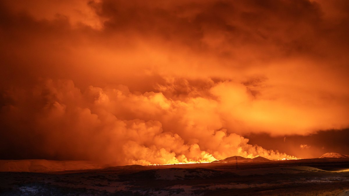 19.12.2023, Island, Grindavik: Der Nachthimmel wird durch den Ausbruch des Vulkans auf der Reykjanes-Halbinsel in Island erhellt. 