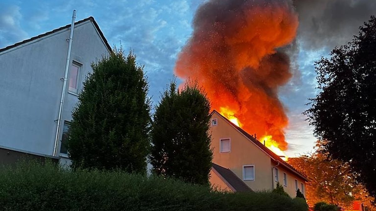 Brennende Scheune hinter einem Haus. 