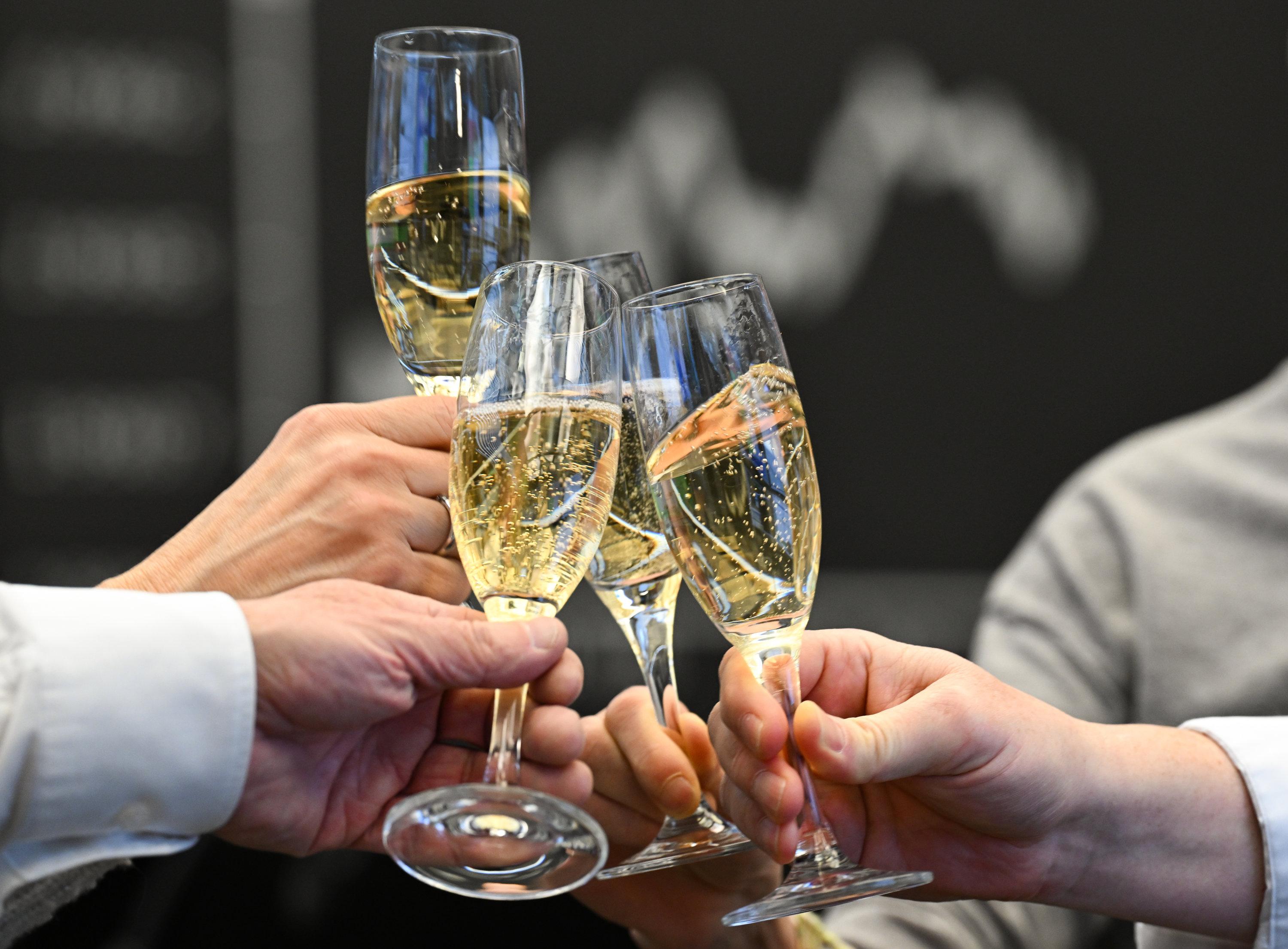 (Symbolbild) Börsenhändler stoßen mit Sekt an.