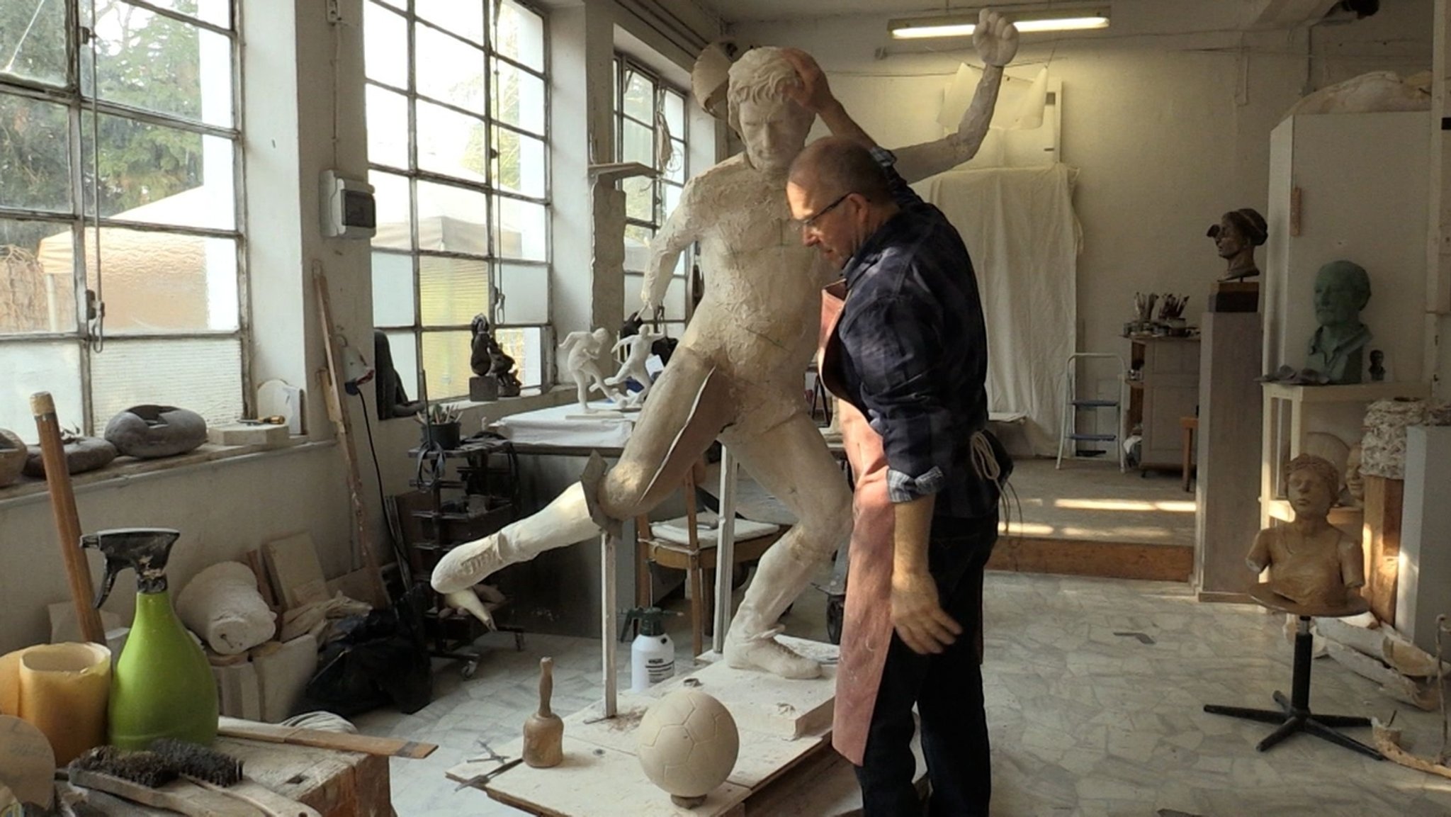 Der Künstler Herbert Deiss arbeitet in seinem Atelier an seiner Gerd Müller-Skulptur