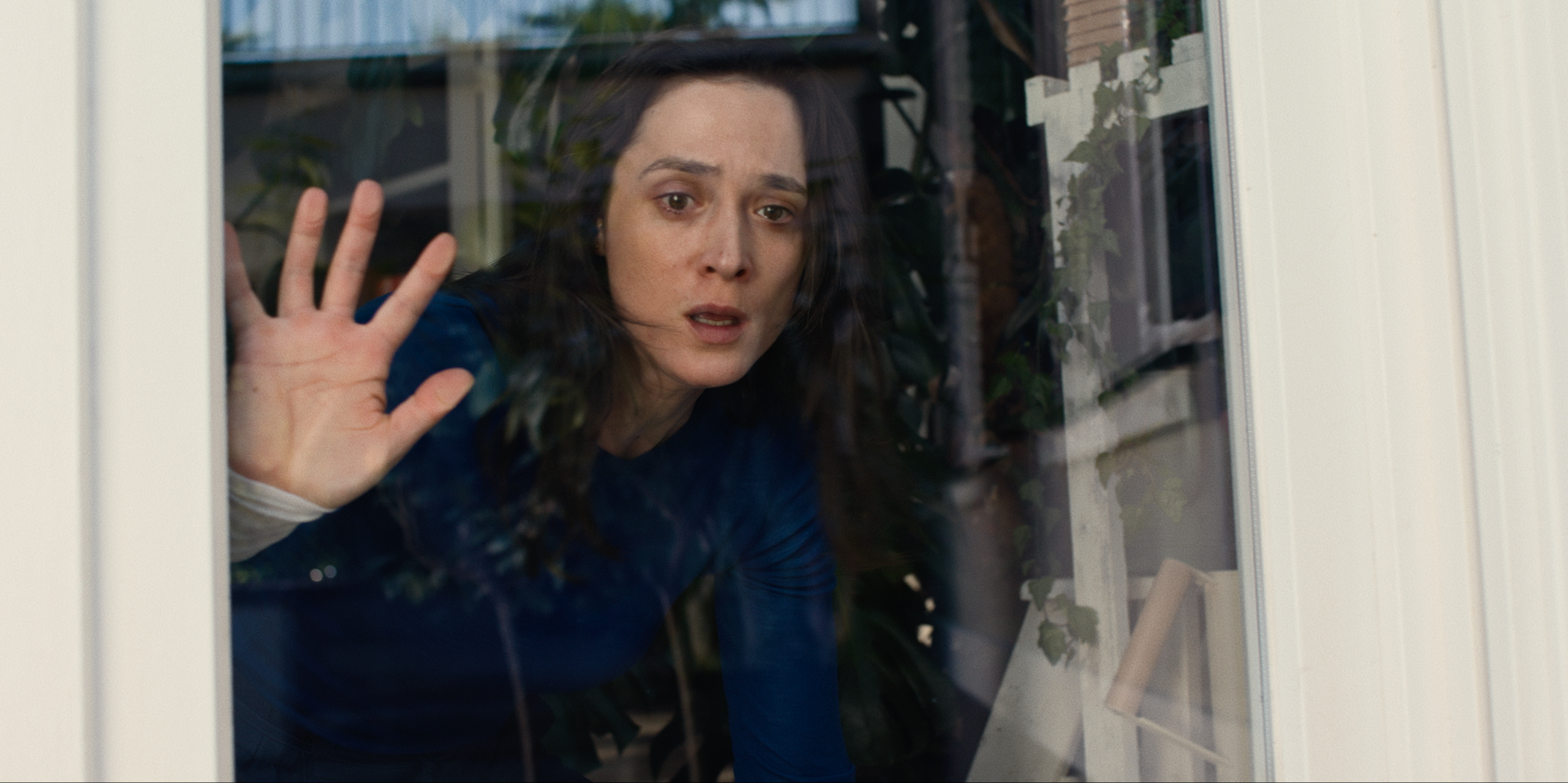 Bildausschnitt aus der Netflix-Serie "Die Falle". Autorin Lisa Konrad (gespielt von Friederike Becht) blickt durch eine Fensterscheibe. | Bild:Netflix 