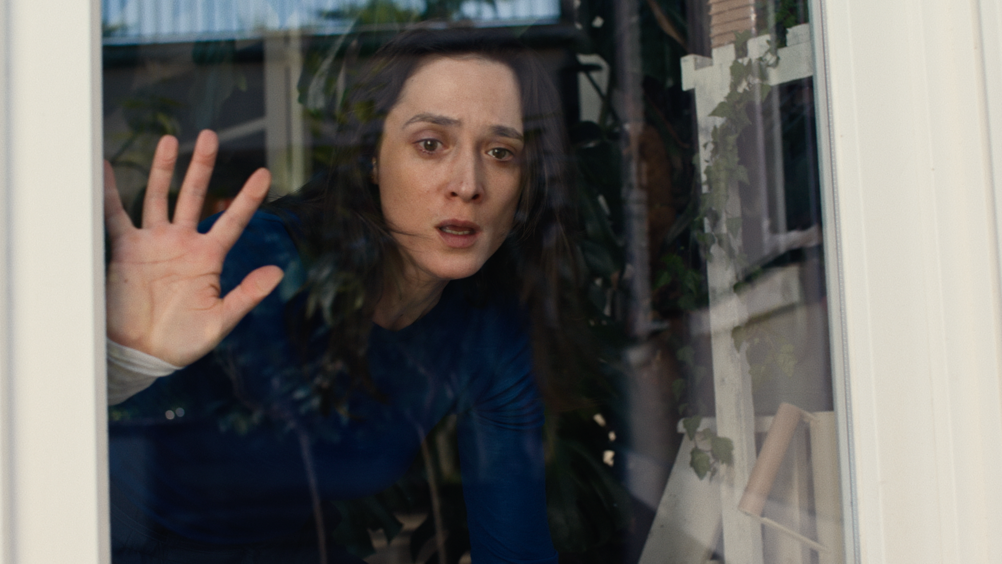 Bildausschnitt aus der Netflix-Serie "Die Falle". Autorin Lisa Konrad (gespielt von Friederike Becht) blickt durch eine Fensterscheibe.