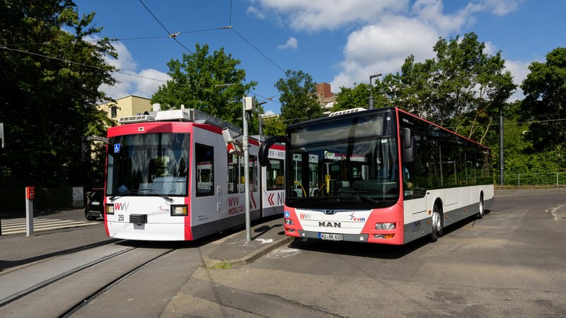 Eine Straßenbahn steht neben einem Bus am Busbahnhof in Würzburg.