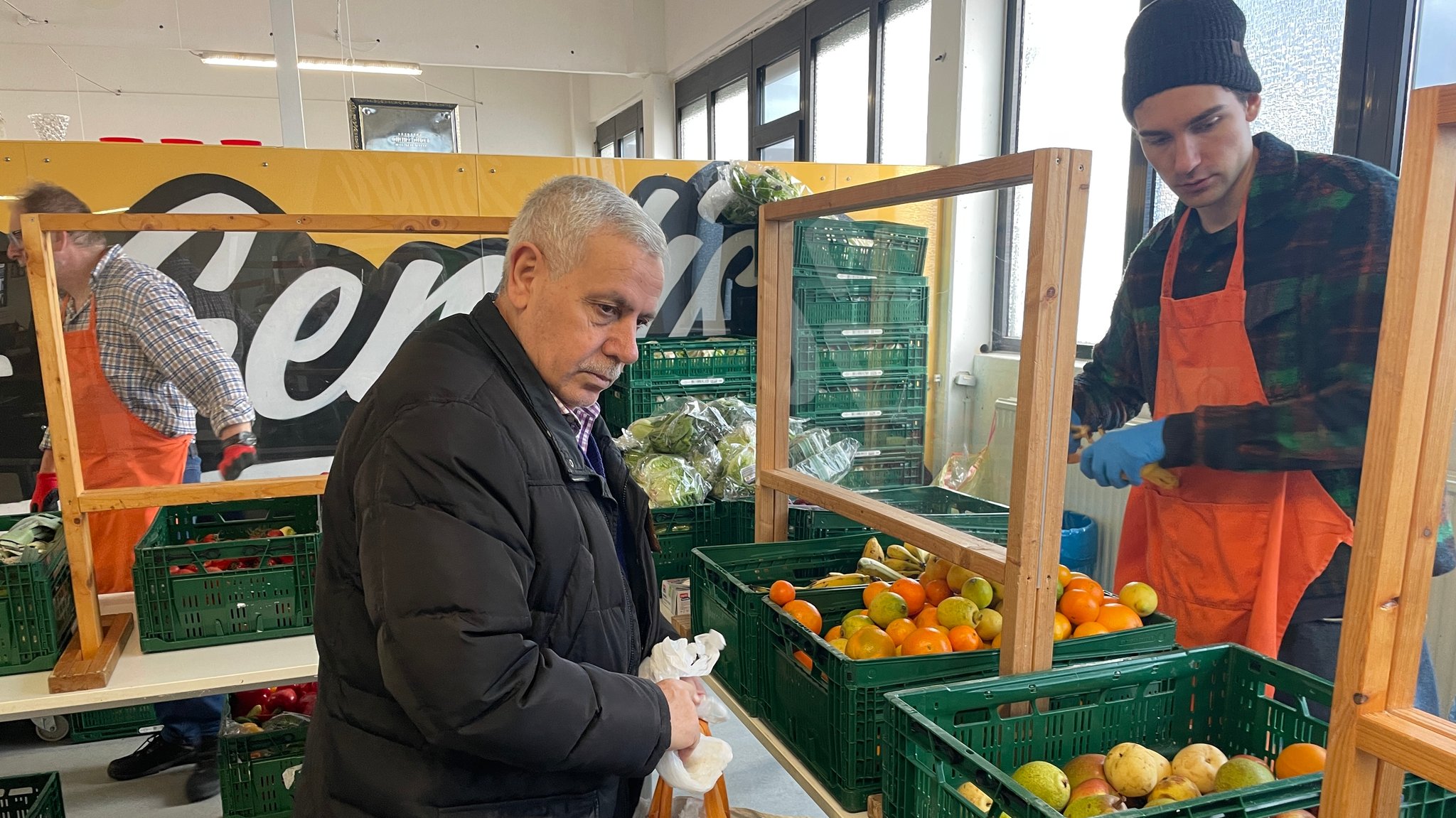 Ein Mann wählt bei der Nürnberger Tafel Obst aus.