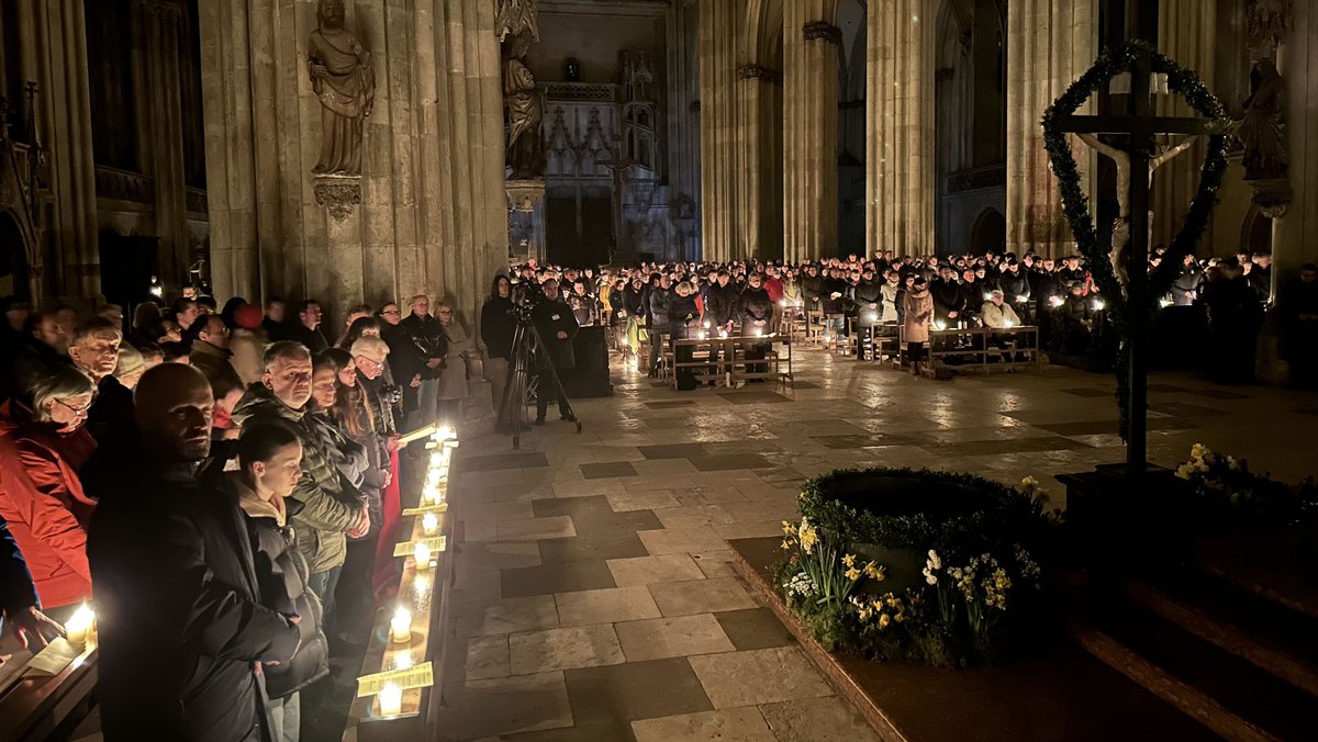 Die Gläubigen im Regensburger Dom Sankt Peter. Die mitgebrachten Kerzen, alle entzündet an einem Osterfeuer, erhellten den zunächst dunklen Dom.