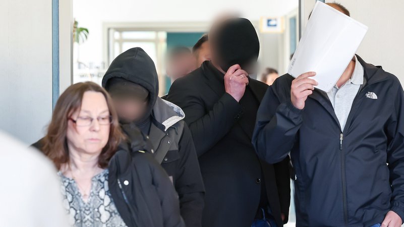 Männer kommen in einen Gerichtssaal. Daneben befindet sich ihre Verteidigerin. | Bild: picture alliance/dpa | Daniel Löb Männer kommen in einen Gerichtssaal. Daneben befindet sich ihre Verteidigerin.