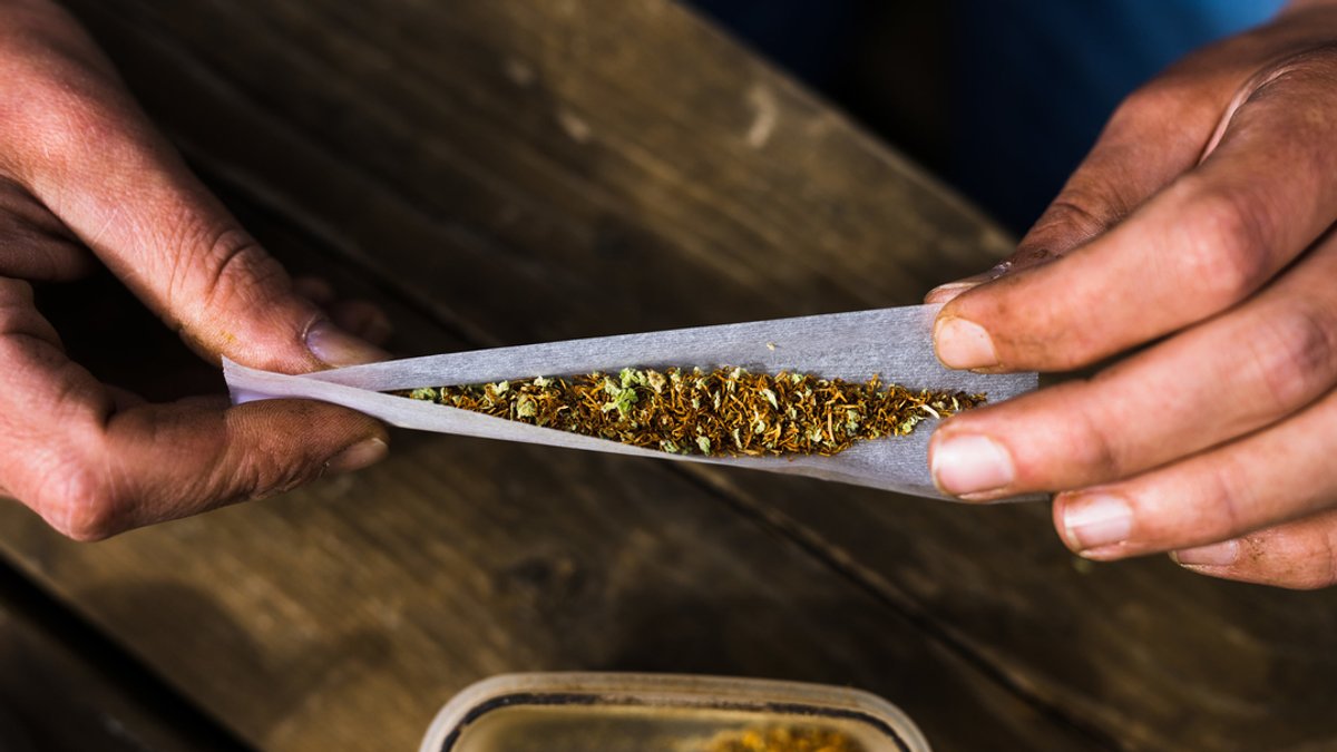 Ein Mann rollt einen Joint aus einer Mischung aus Tabak und Cannabis.