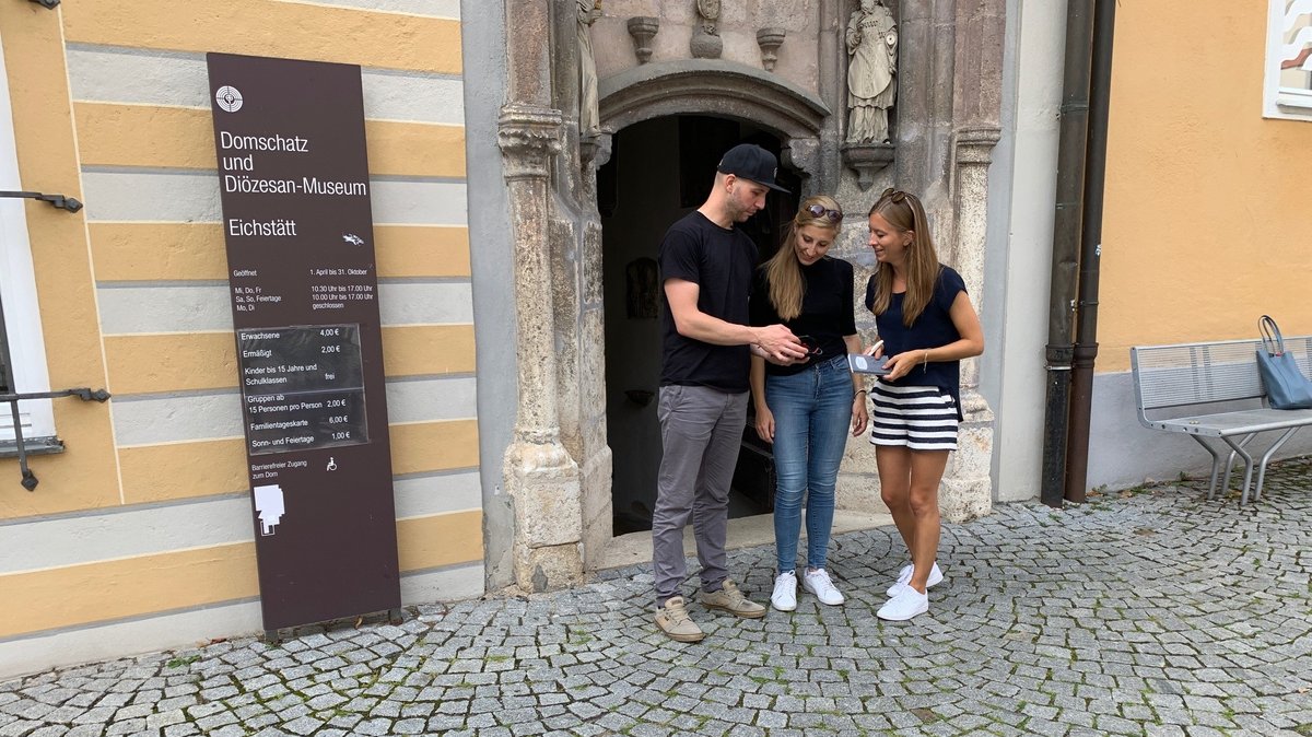 Drei Freunde mit Smartphone vor dem Eichstätter Domschatz- und Diözesanmuseum.