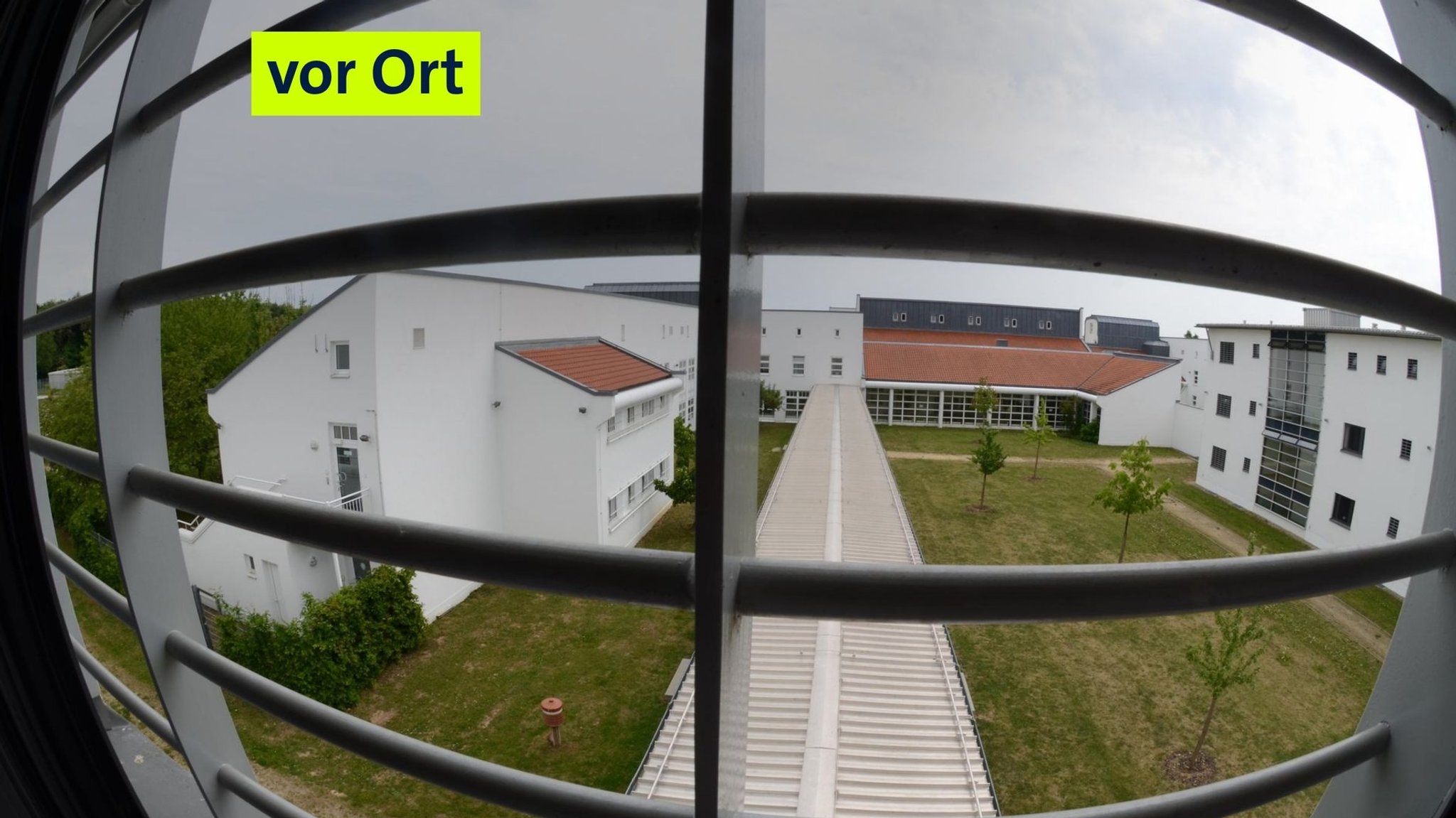 Ein Blick durch vergitterte Fenster in den Innenhof des Bezirkskrankenhauses. 