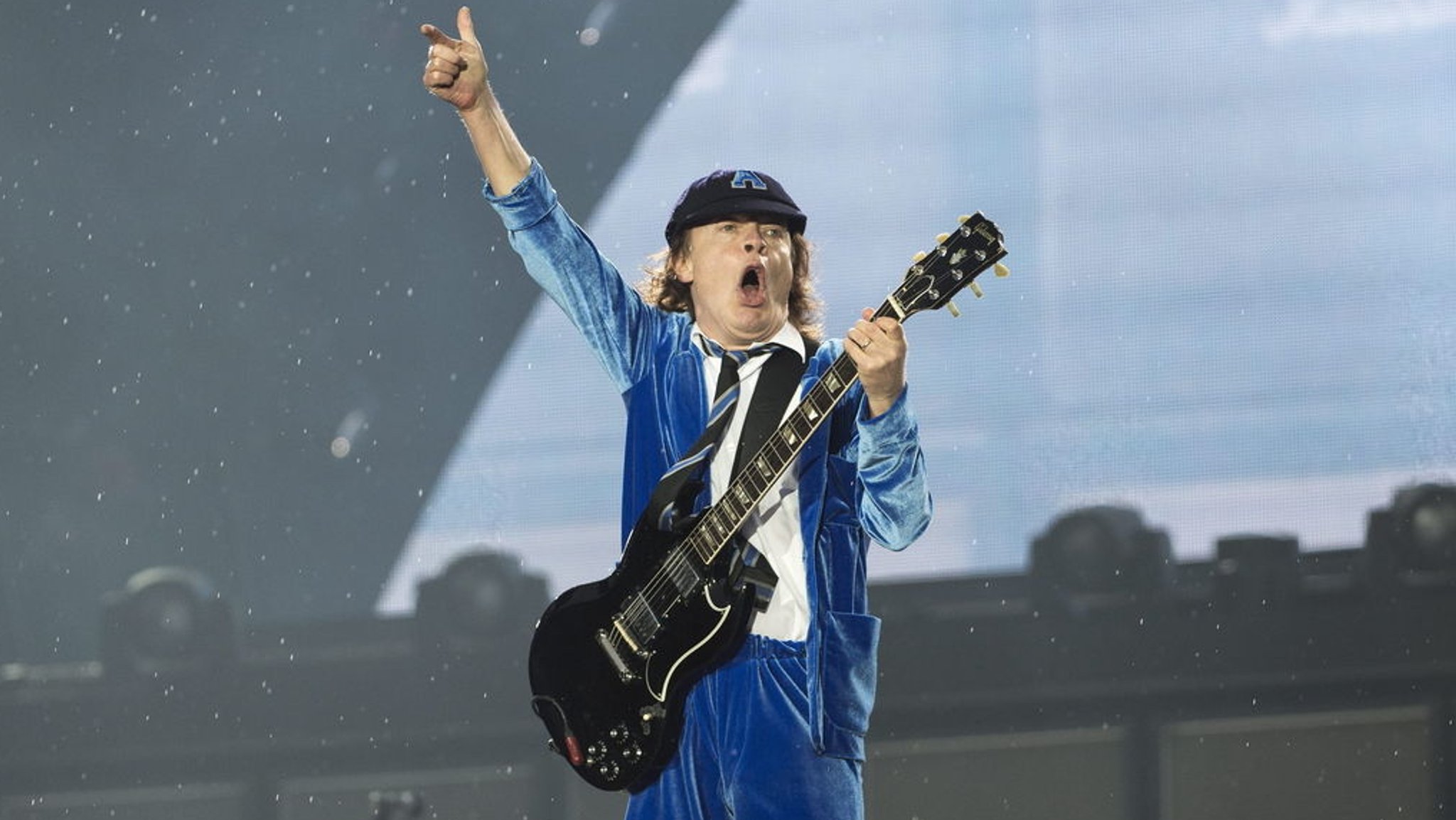 ARCHIV - 29.05.2016, Schweiz, Bern: Der australische Gitarrist Angus Young von der australischen Hardrock-Band AC/DC tritt während des Welttourneekonzerts "Rock or Bust" im Stadion Stade de Suisse in Bern auf. Im Sommer gehen AC/DC nach langer Pause wieder auf Tournee. 