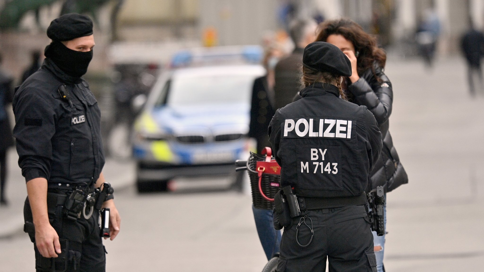 Polizisten kontrollieren in der Innenstadt die Einhaltung der Maskenpflicht bei einer Radfahrerin.