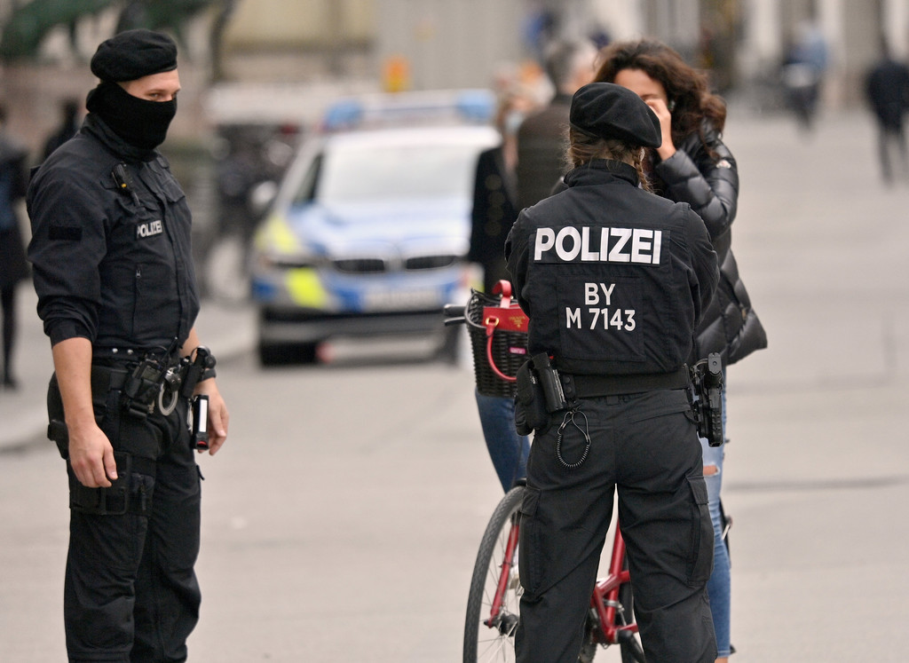 Polizisten kontrollieren in der Innenstadt die Einhaltung der Maskenpflicht bei einer Radfahrerin.