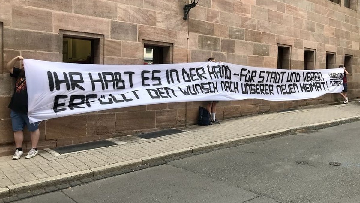 Fans des 1. FCN Nürnberg mit einem Transparent vor dem Rathaus