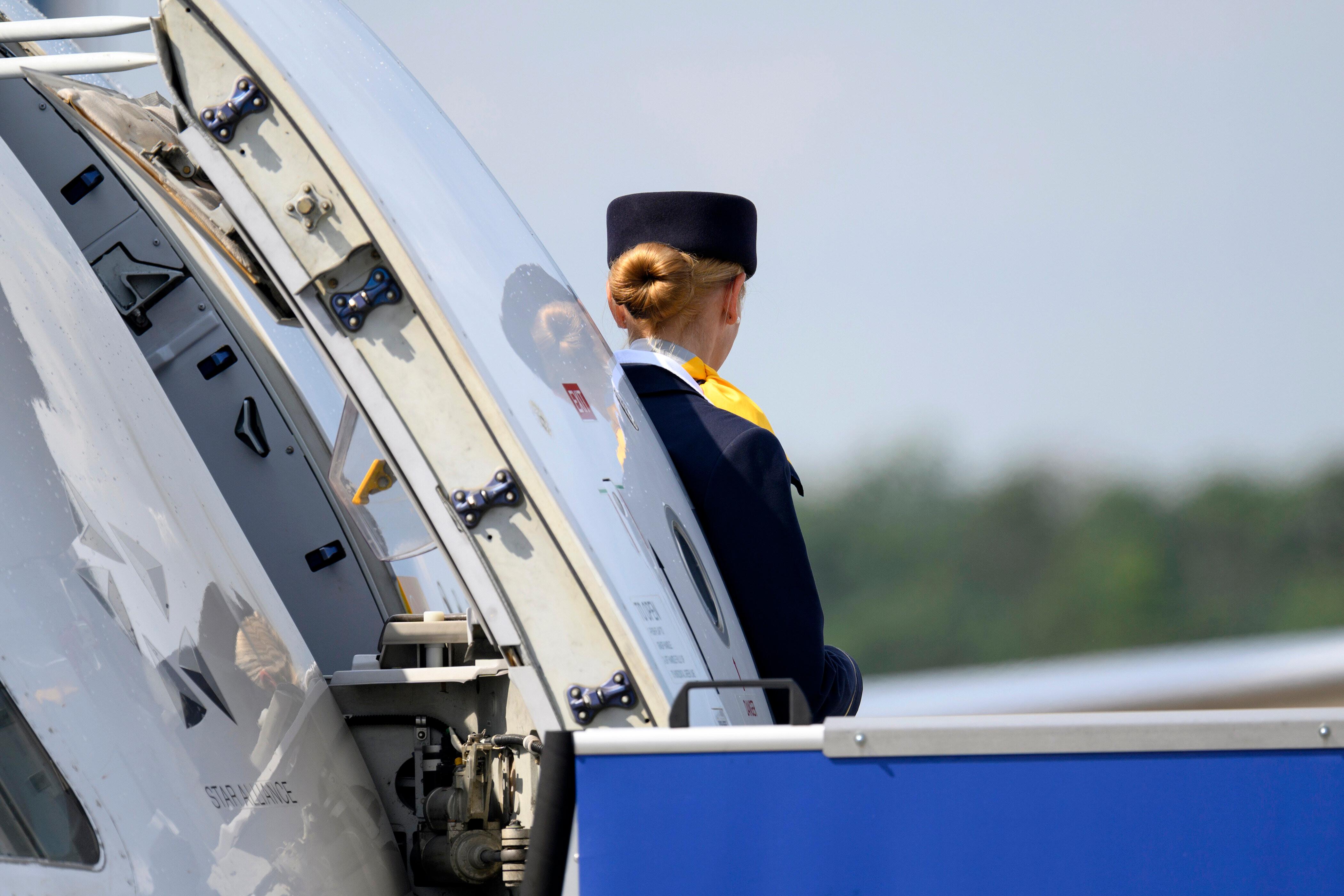 Lufthansa-Stewardess an Flugzeugtüre.