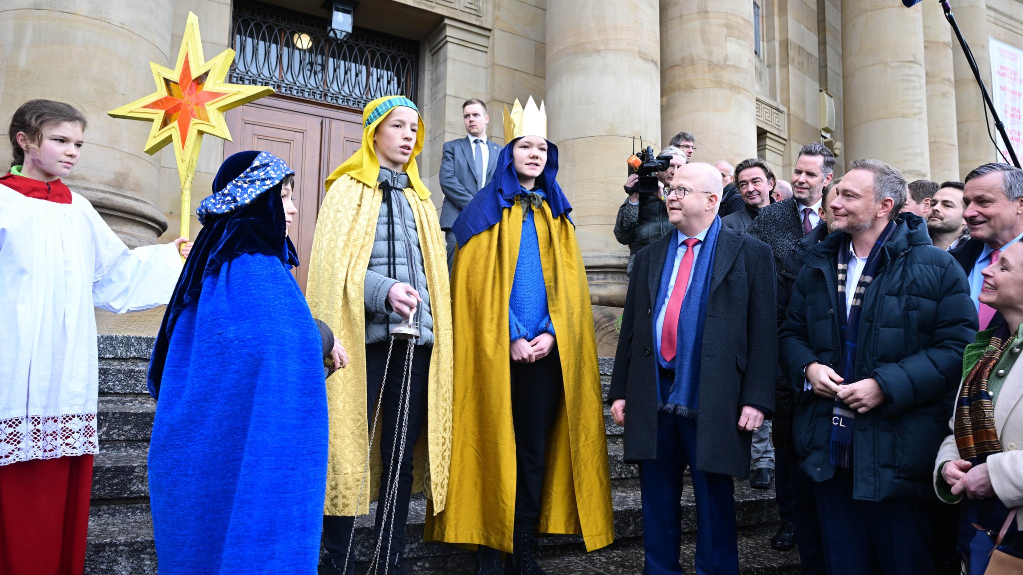 Michael Theurer (vorn 2.v.r), Landesvorsitzender der FDP Baden-Württemberg, und Christian Lindnder (r), Bundesvorsitzender der FDP und Bundesfinanzminister, stehen vor dem Opernhaus beim traditionellen Dreikönigstreffen der FDP zusammen mit einer Gruppe Sternsinger.