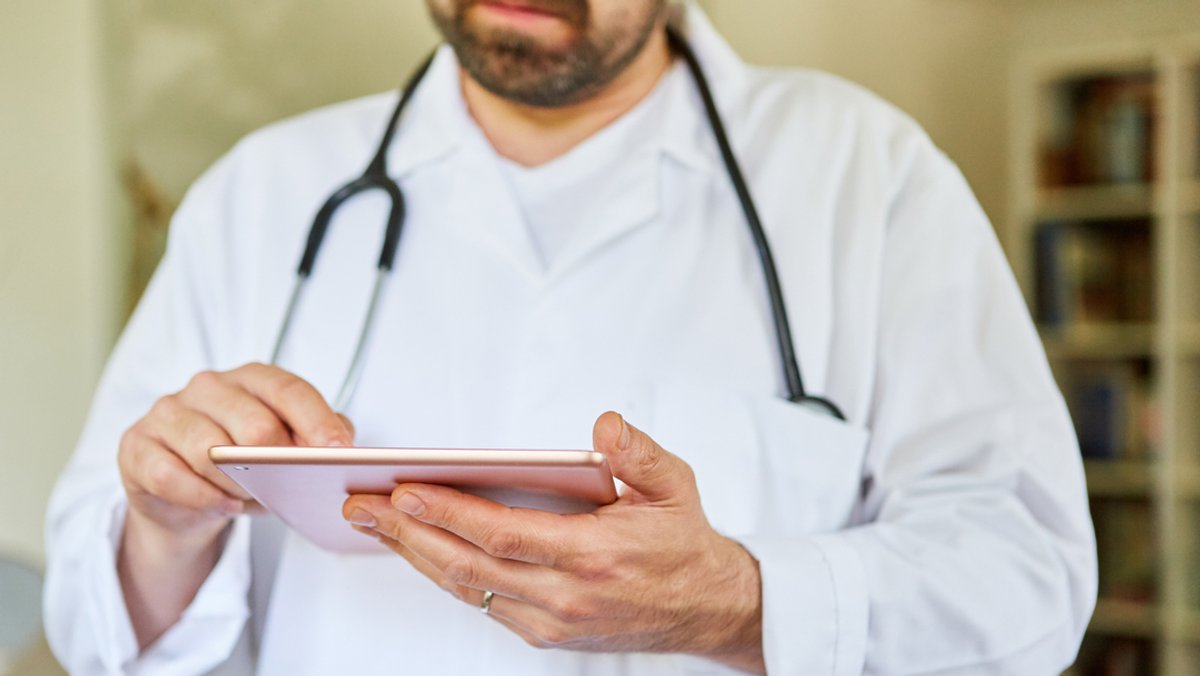 Ein Arzt nutzt Tablet Computer für digitale Patientenakte.
