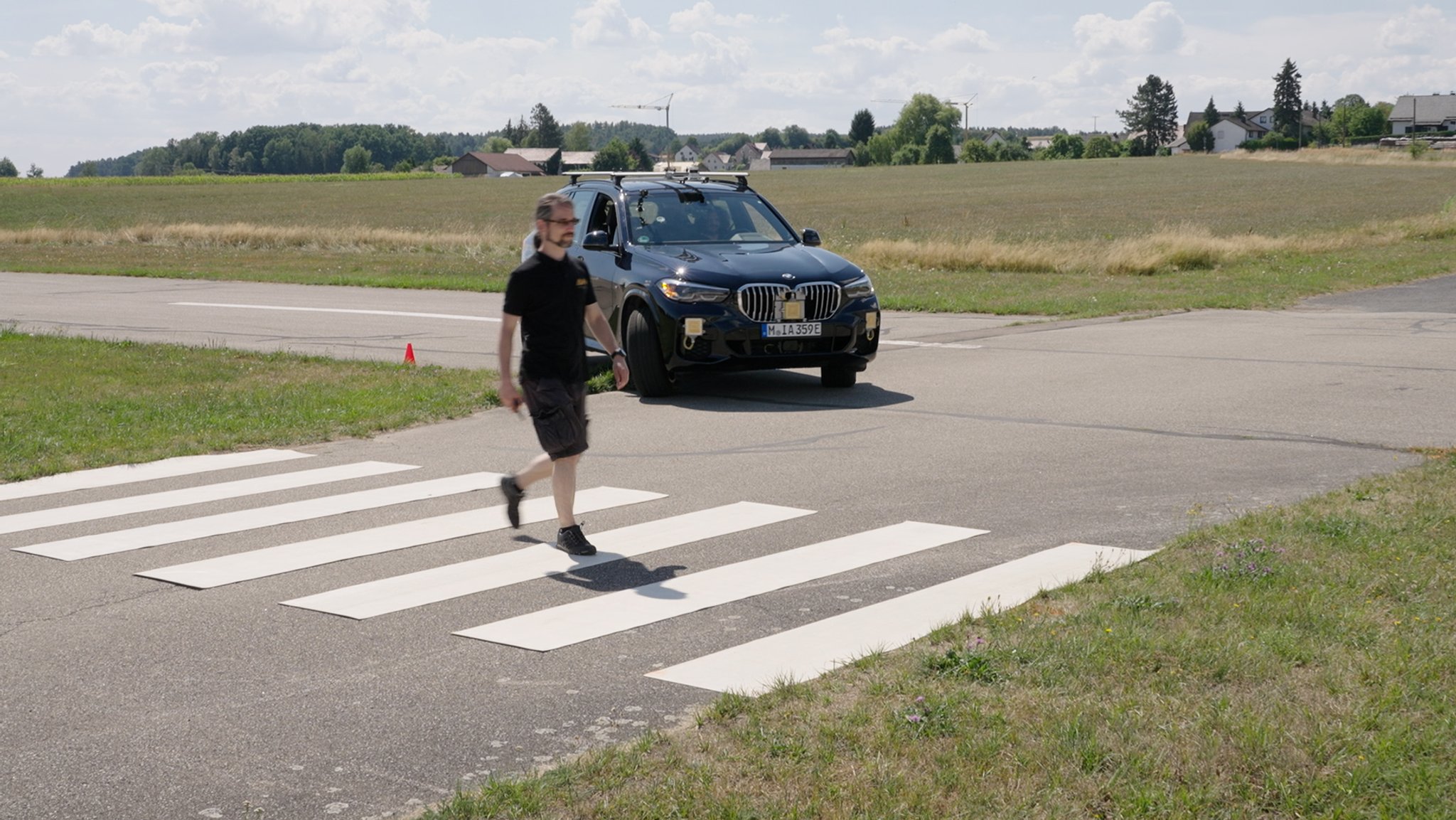 Das Versuchsauto biegt an einem Zebrastreifen ab. Die verschiedenen Sensoren erfassen den Fußgänger.