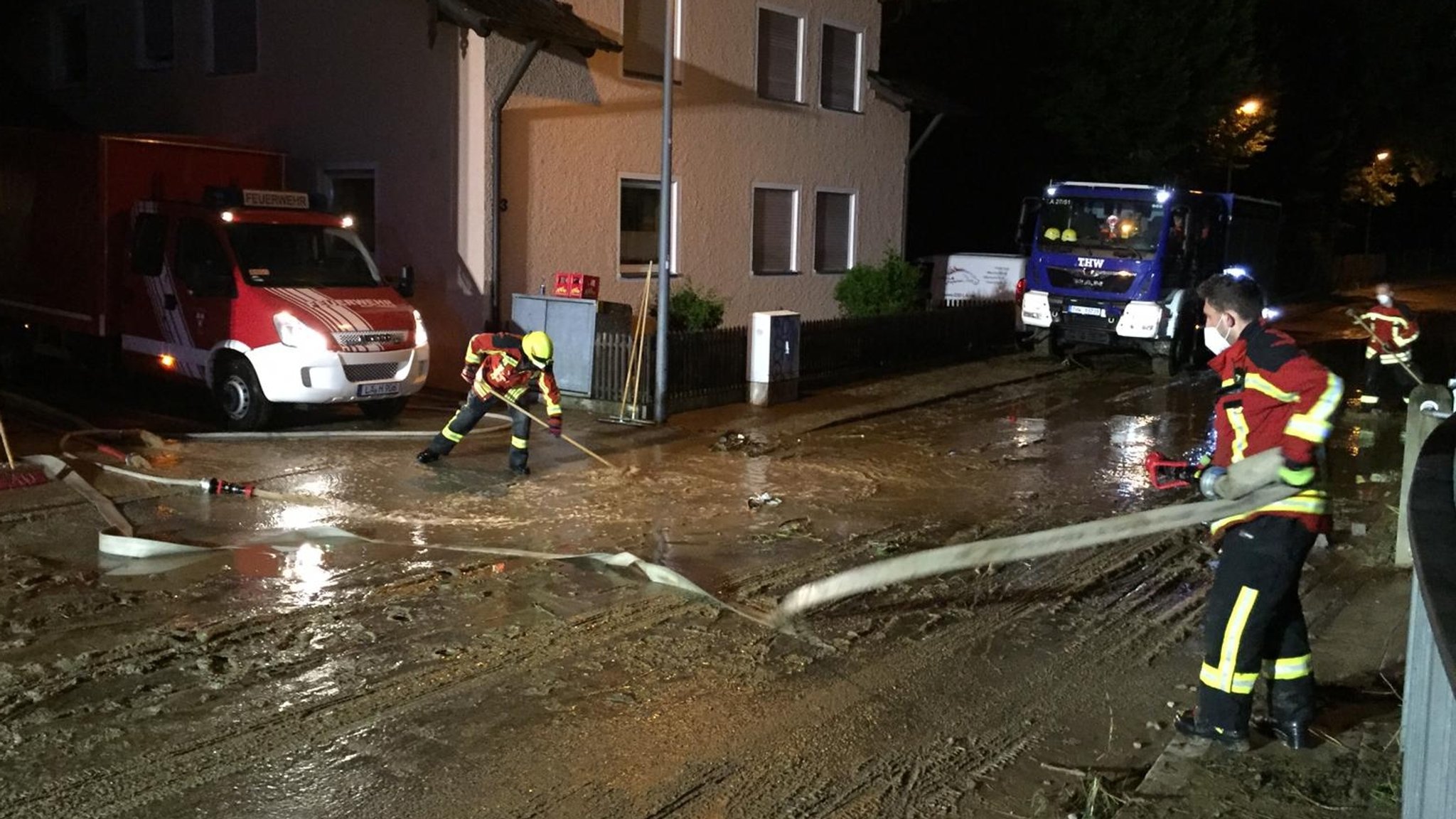 Feuerwehr und THW reinigen eine Straße in Landshut