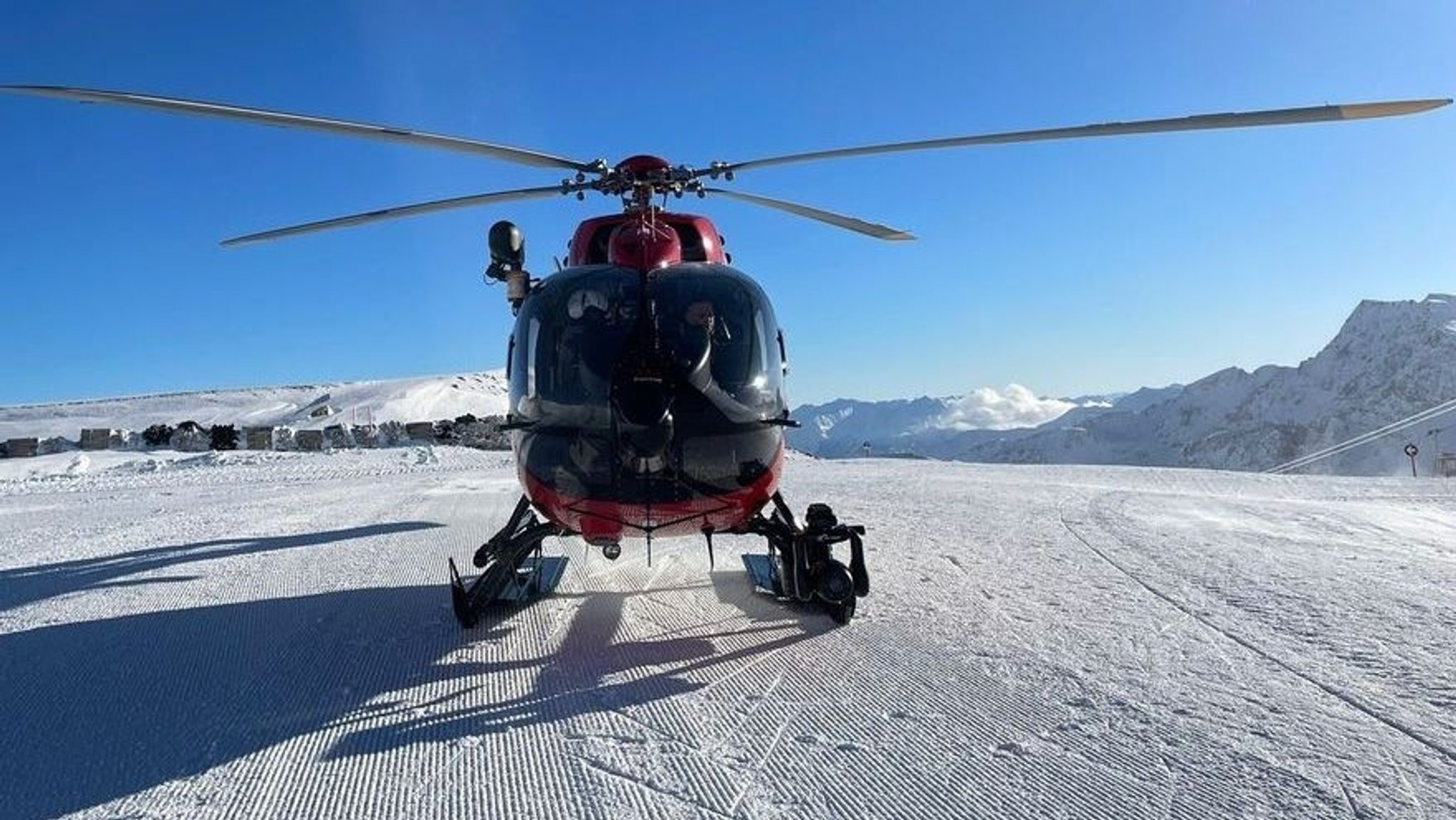 Ein Hubschrauber auf einem schneebedeckten Berg. Er wird bei Lawinenunglücken zur Flugrettung eingesetzt. (Symbolbild)