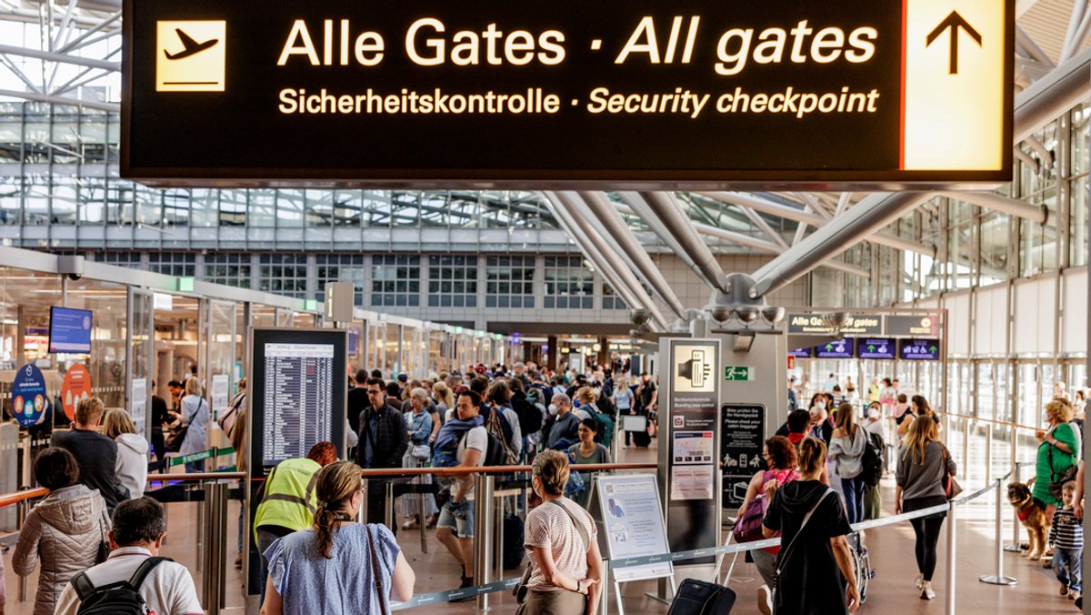 Andrang zur Sommerreisezeit: Fluggäste warten im Flughafen in Hamburg vor dem Sicherheitscheck auf die Abfertigung. 