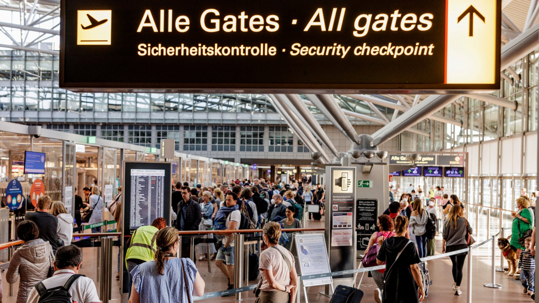 Andrang zur Sommerreisezeit: Fluggäste warten im Flughafen in Hamburg vor dem Sicherheitscheck auf die Abfertigung. 