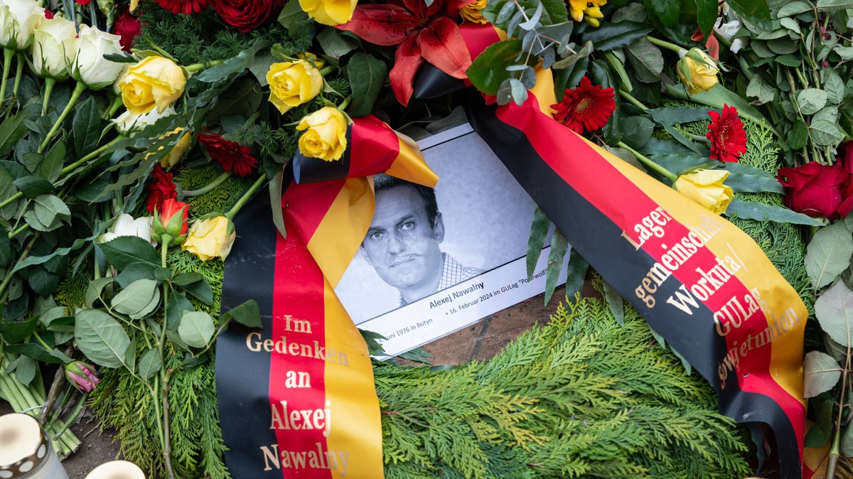 Berlin, Deutschland, Europa - Eine improvisierte Gedenkstaette aus Blumen, Kerzen und Bildern fuer den russischen Oppositionsfuehrer Alexei Nawalny ist auf dem Boden vor der russischen Botschaft U
