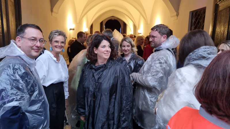 Gloria von Thurn und Taxis flüchtet sich mit Gästen in einen Durchgang zum Schlosshof. | Bild: BR/Marcel Kehrer Gloria von Thurn und Taxis flüchtet sich mit Gästen in einen Durchgang zum Schlosshof.