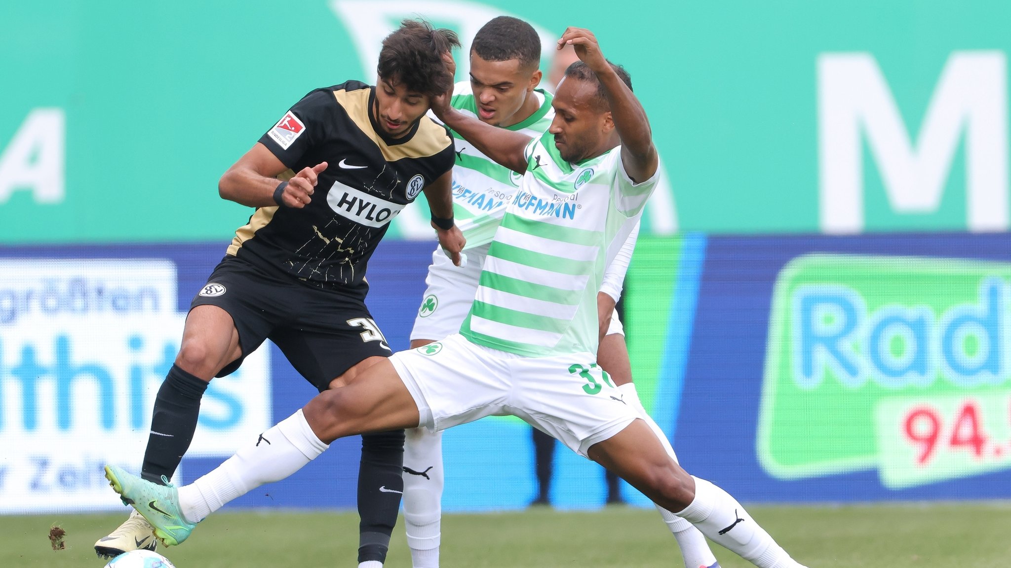 Julian Green (r) von Greuther Fürth attackiert Muhammed Mehmet Damar (l) vom SV Elversberg.