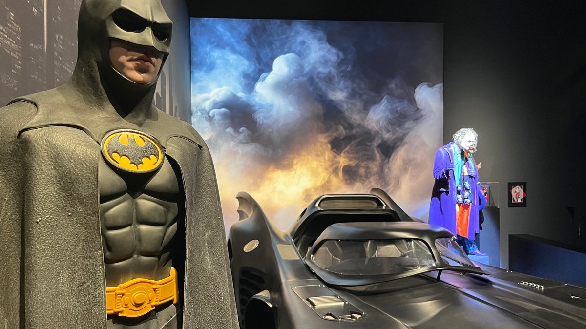 Der Nachbau eines "Batmobil" steht zwischen einem lebensgroßen "Batman" (l.) und einer "Joker"-Figur.