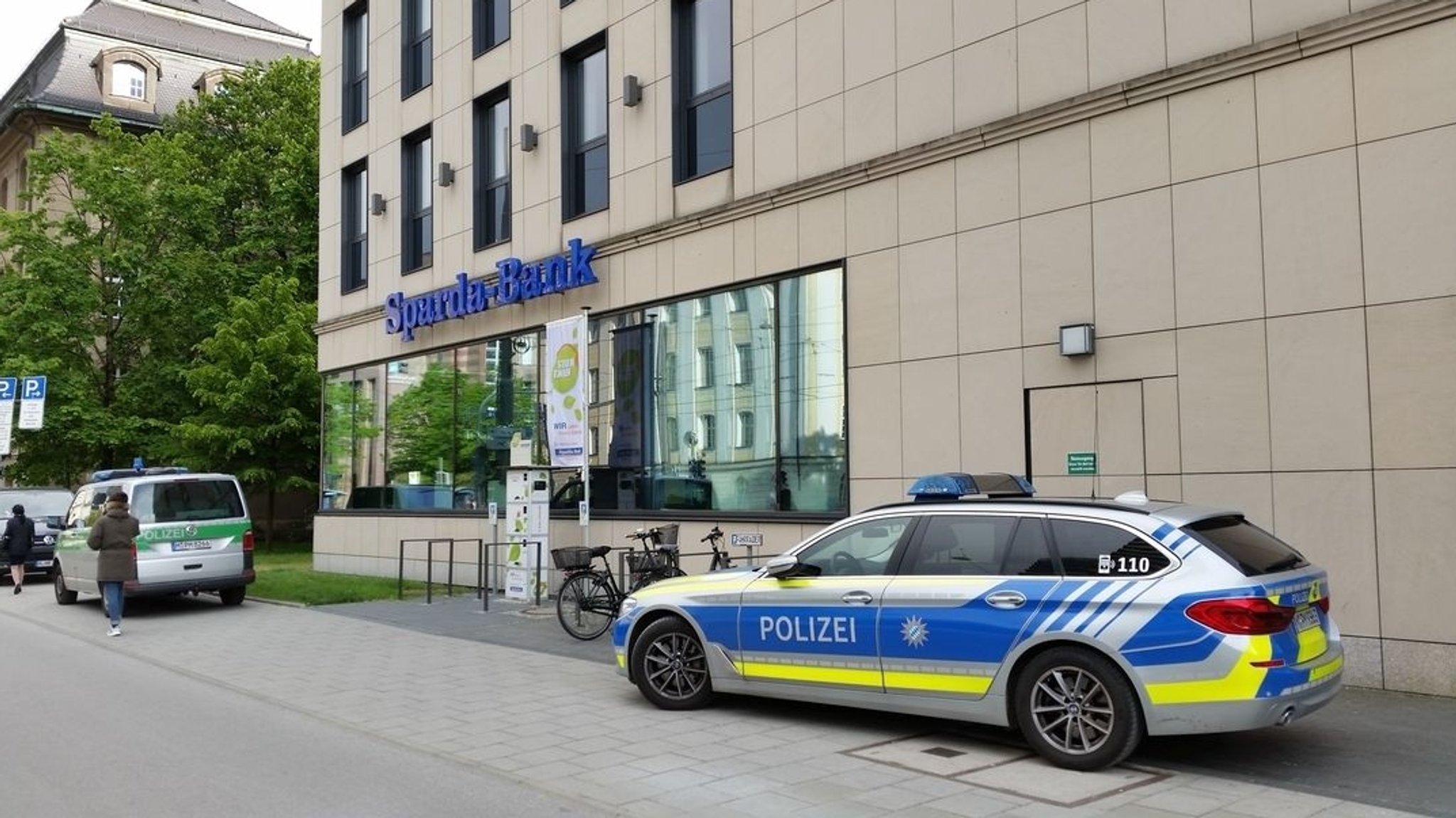 Polizei-Einsatzfahrzeuge vor der überfallenen Sparda-Bank