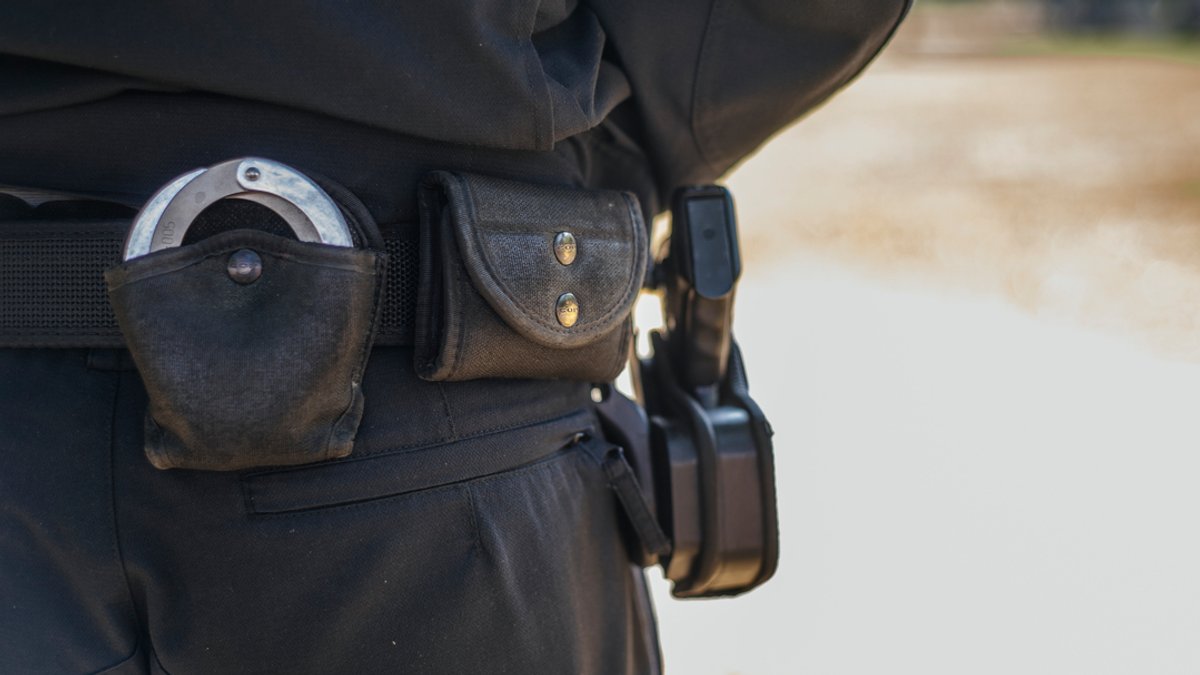 Handschellen am Gürtel eines Polizisten (Symbolbild)