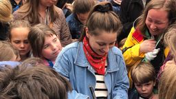 Checkerin Marina verteilt Autogramme beim Kinderfest in Würzburg. | Bild:BR/Laura Pickert