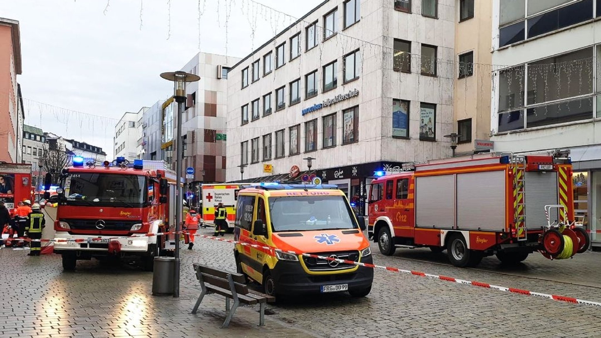 Einsatzkräfte von Feuerwehr und Rettungsdienst stehen in der Innenstadt am Einsatzort. 