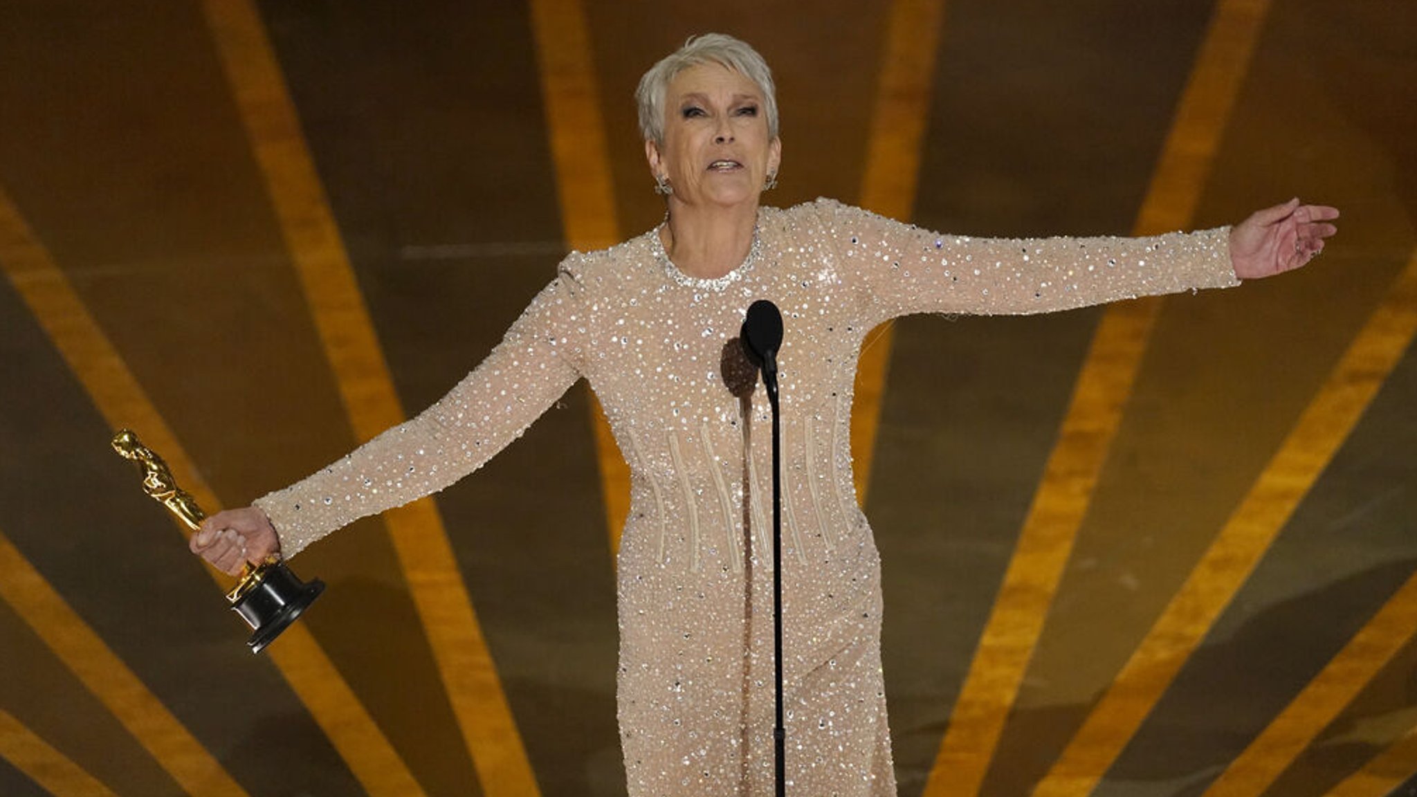 Schauspielerin Jamie Lee Curtis nimmt den Preis für die beste Leistung als Nebendarstellerin für «Everything Everywhere All at Once» bei der Oscar-Verleihung im Dolby Theatre in Los Angeles entgegen. Foto: Chris Pizzello/Invision/AP +++ dpa-Bildfunk +++