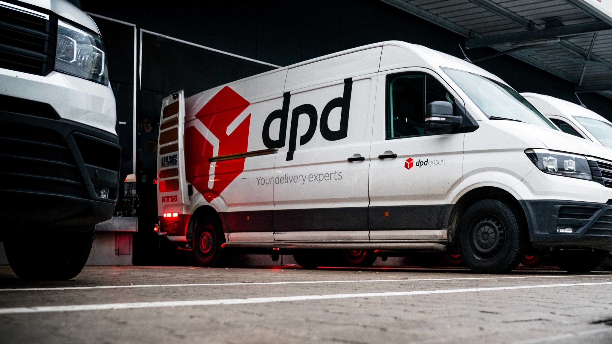 (Symbolbild) Transporter von DPD stehen geparkt in einer Reihe | Bild: picture alliance / ANP | ROB ENGELAAR (Symbolbild) Transporter von DPD stehen geparkt in einer Reihe