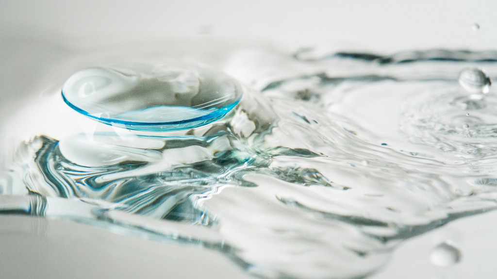 Eine Kontaktlinse schwimmt auf Flüssigkeit. Über Toilette oder Waschbecken entsorgt, landen Kontaktlinsen am Ende als Mikroplastik im Meer.