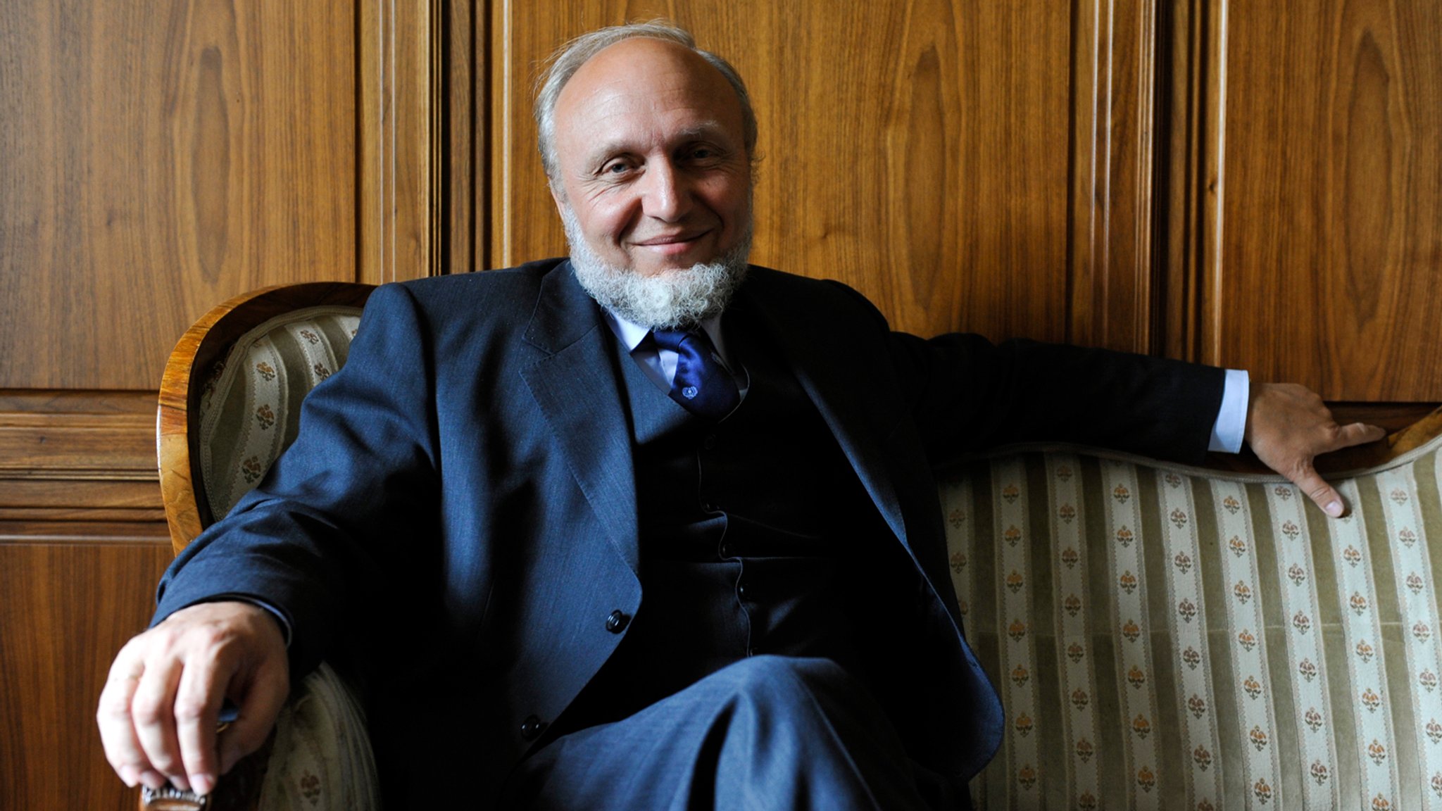 Hans-Werner Sinn sitzt auf einem Sofa.