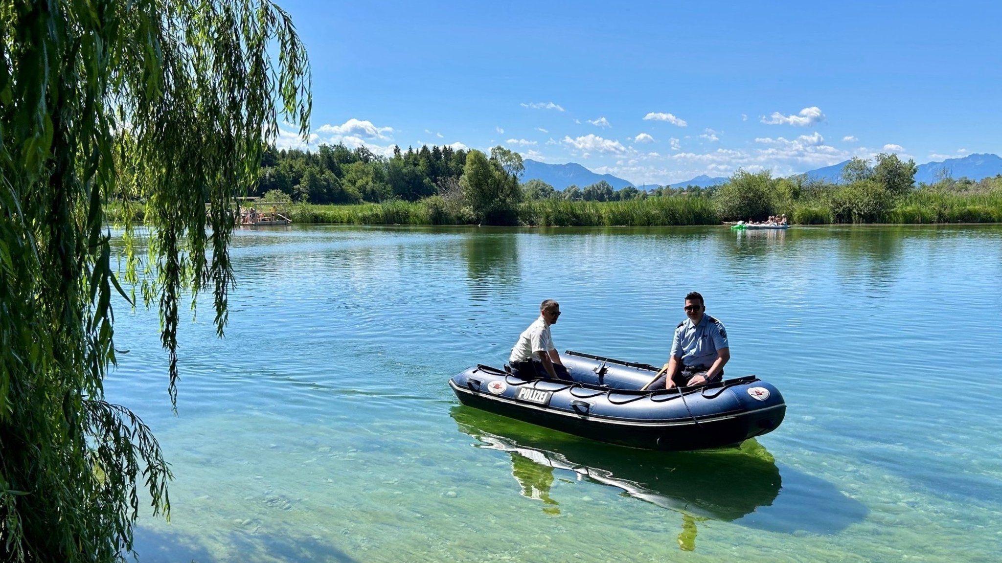 Man sieht zwei Menschen in einem Schlauchboot auf der Alz.