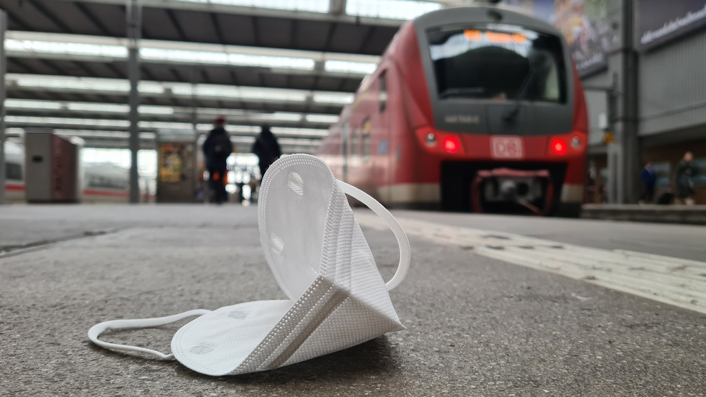 Eine FFP2-Maske liegt an einem Bahnsteig