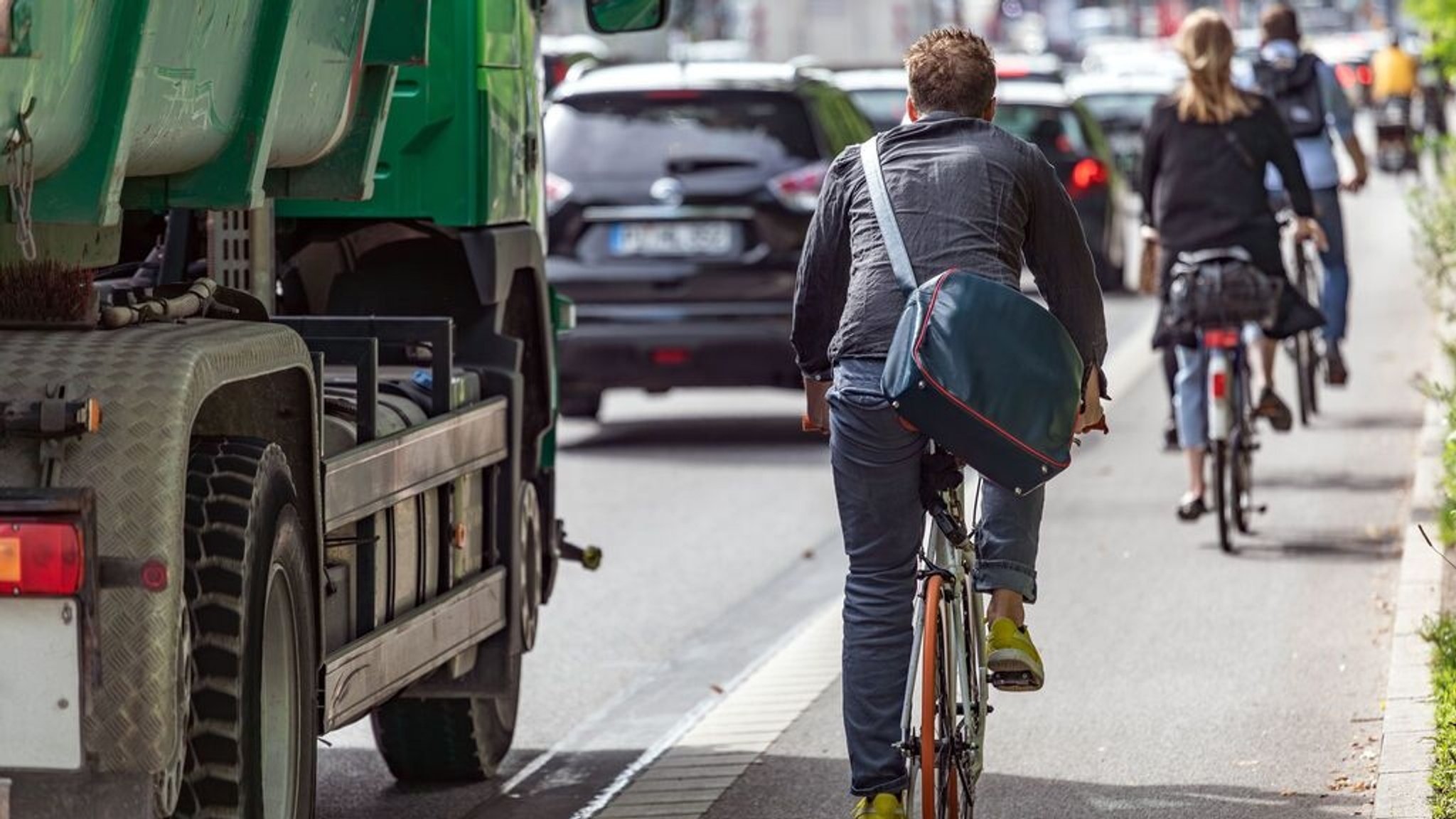 Mann fährt in der Stadt auf einem Fahrrad Weg neben der Straße.