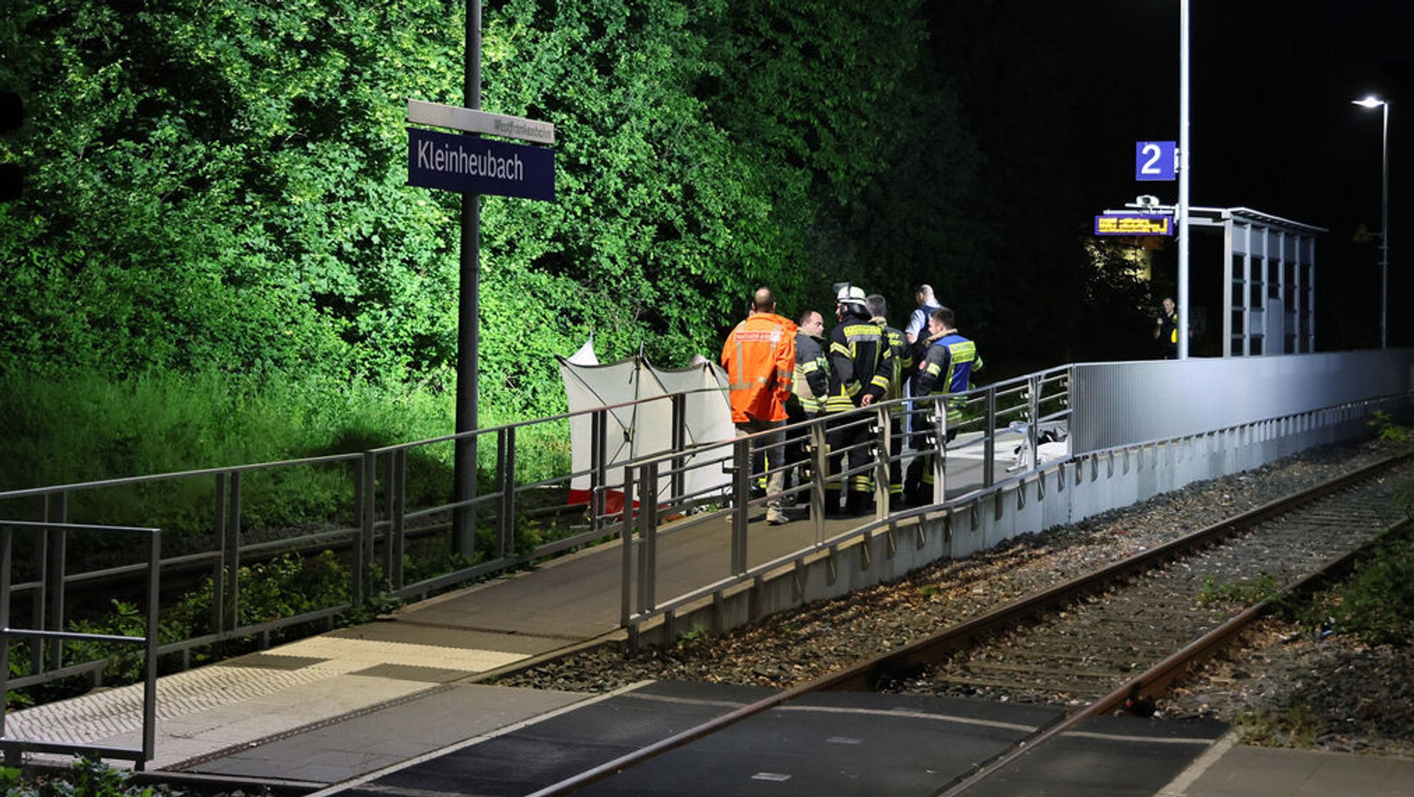 ARCHIV - 18.05.2024, Bayern, Kleinheubach: Rettungskräfte stehen an einem Bahnsteig in Kleinheubach. (zu dpa: «Männer von Zug überrollt - Polizei vermutet Streit als Auslöser») Foto: Ralf Hettler/dpa +++ dpa-Bildfunk +++