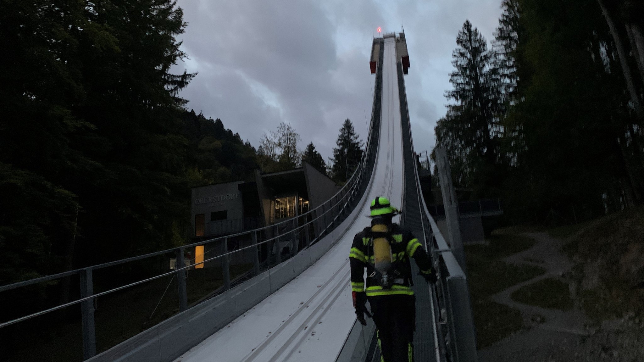 Feuerwehrleute in voller Montur laufen die Heini-Klopfer-Schanze hoch. 