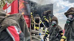 Feuerwehrkräfte kommen nach der Schulung aus dem Brandcontainer. | Bild:BR/Hans Mielich