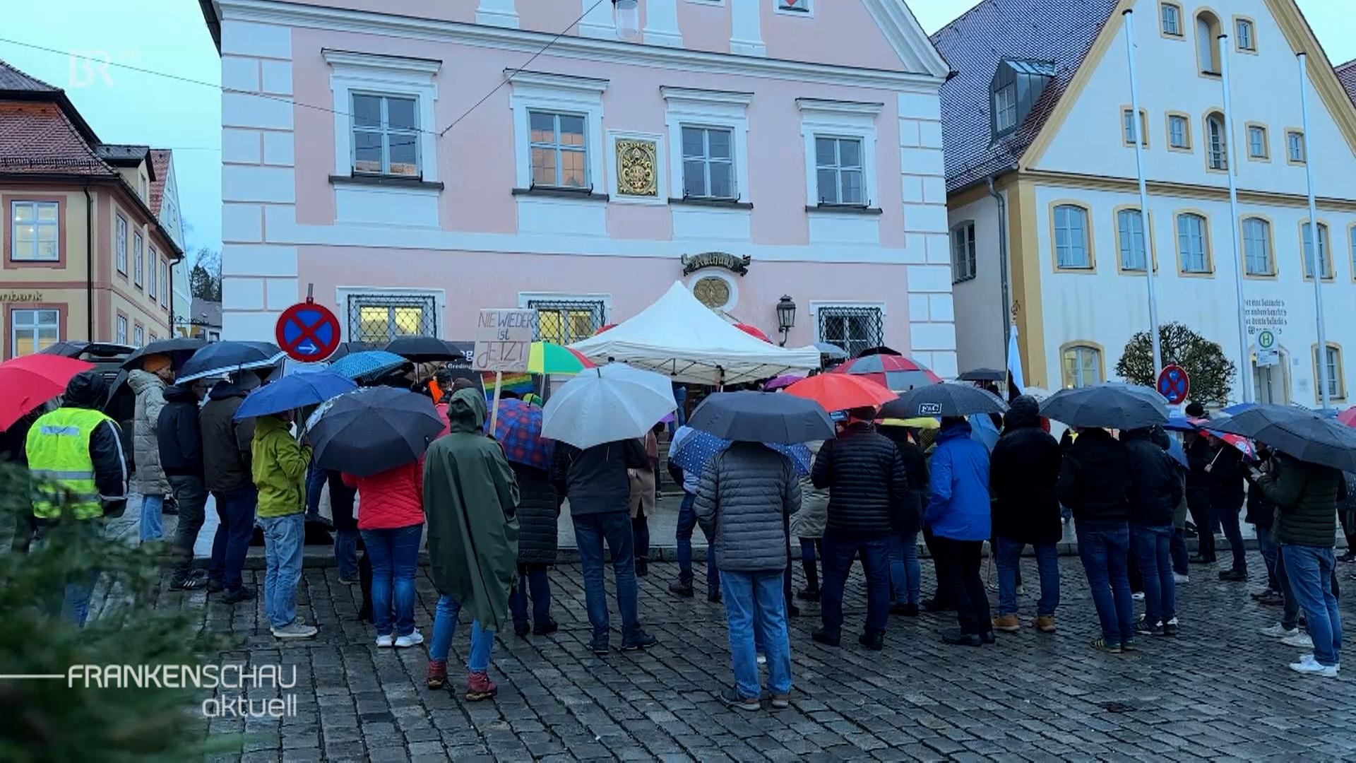 Menschen mit Regenschirmen stehen zusammen-.