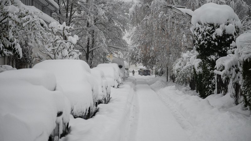 02.12.2023, Bayern, München: Hohe Schneemassen liegen auf Autos und einer Straße in der Landeshauptstadt. Schnee und Eis haben im Süden Bayerns auf den Straßen und bei der Bahn für Chaos gesorgt. Foto: Lukas Barth/dpa +++ dpa-Bildfunk +++