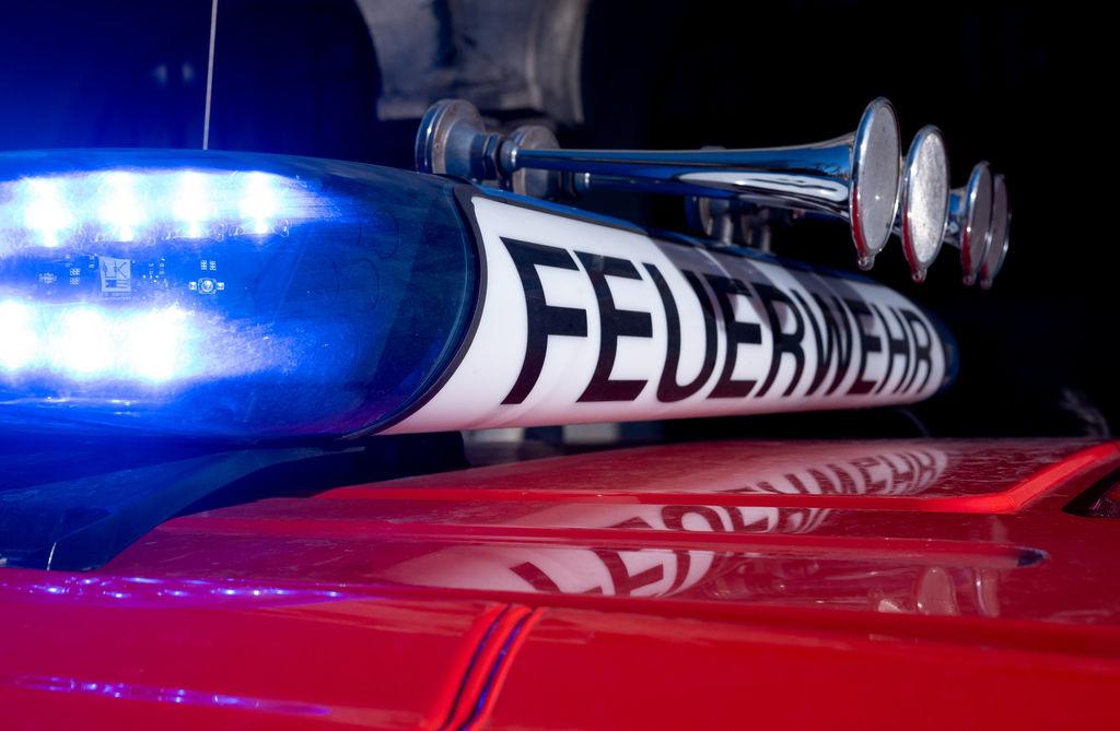 Das Dach eines Feuerwehreinsatzautos mit eingeschaltetem Blaulicht.