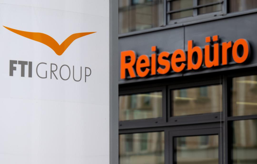 Das Logo des Reiseveranstalter FTI (FTI Group) steht an der Firmenzentrale vor einem Reisebüro.