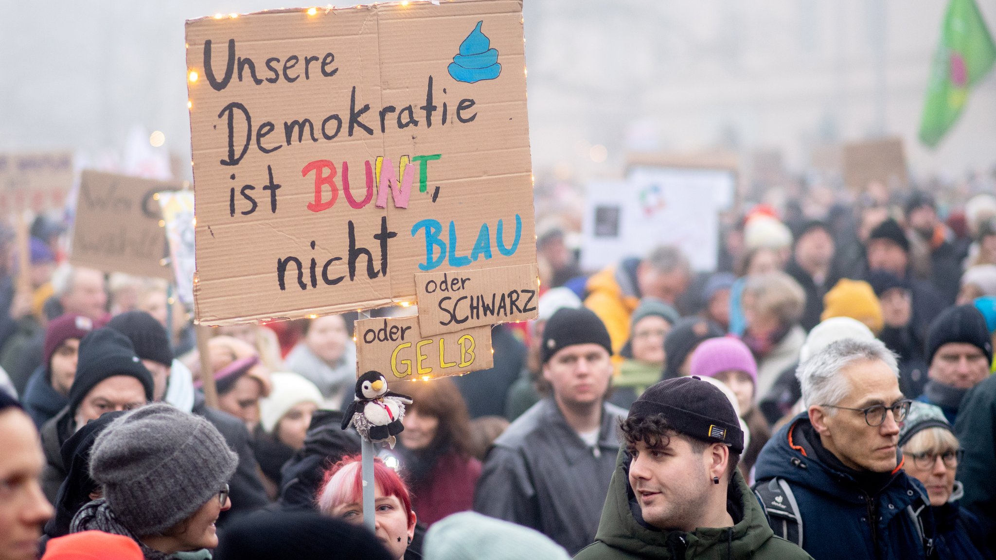 01.02.2025, Niedersachsen, Oldenburg: Zahlreiche Menschen nehmen bei dichtem Nebel mit Plakaten an einer Demonstration gegen rechte Parteien und die gemeinsame Abstimmung von Union und AfD für eine schärfere Migrationspolitik auf dem Schlossplatz teil.